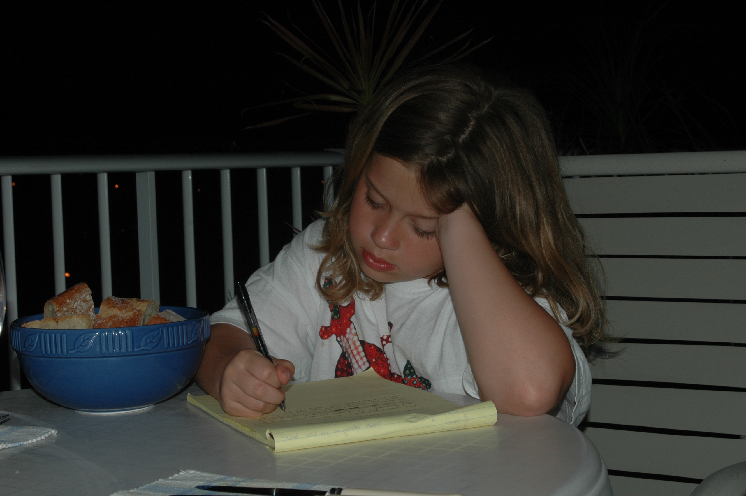 Lael as a child, writing on a yellow legal pad